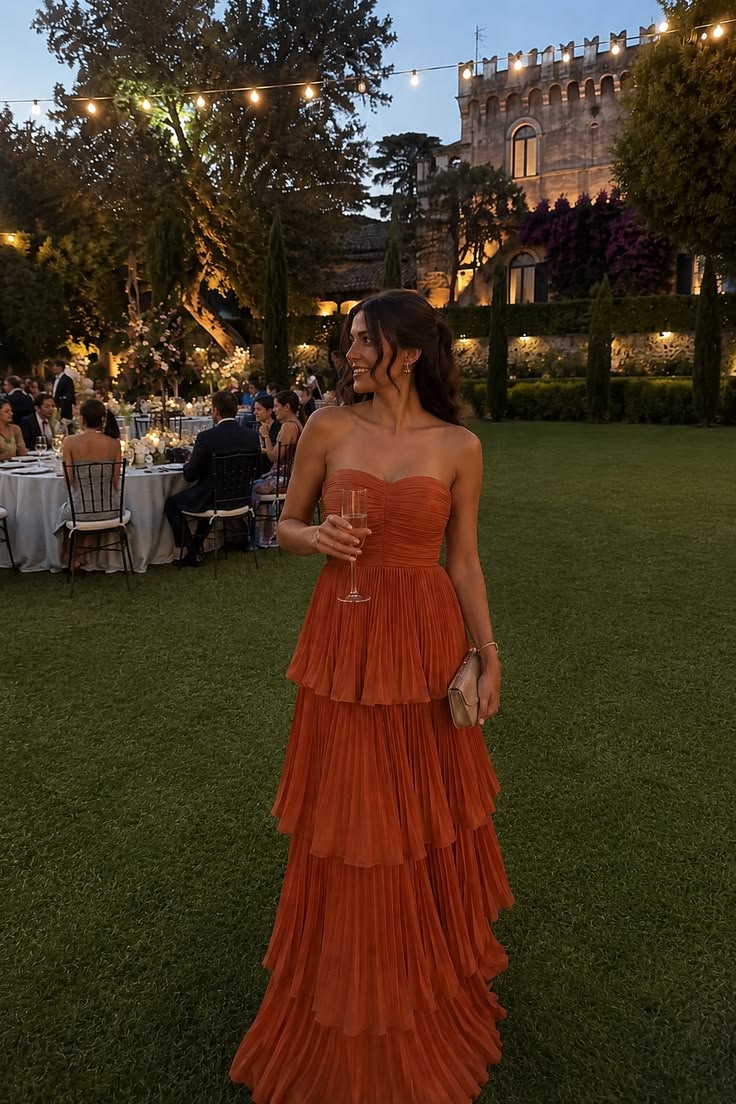 Terracotta pleated evening gown at an outdoor celebration